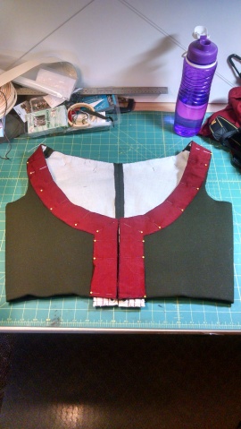 Red gaurd lining pinned into place, you can see the lacing strips extending past the bodice to help keep the lower tummy flat.